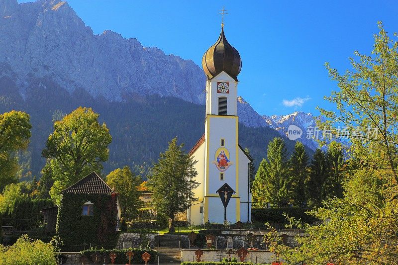 巴洛克式的圣约翰尼斯德尔Täufer教堂在Grainau阿尔卑斯村与Zugspitze, Waxenstein和Alpspitze景观-戏剧性的风景在巴伐利亚阿尔卑斯山，德国，附近的Karwendel山脉-雄伟的高山景观秋天-加尔米施，德国巴伐利亚